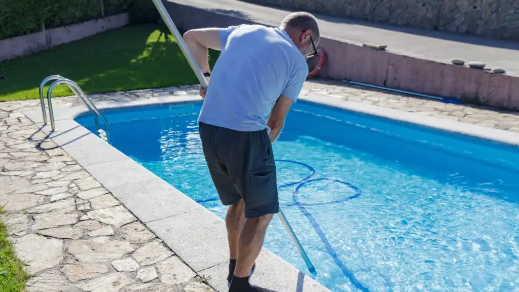 man cleaning a pool